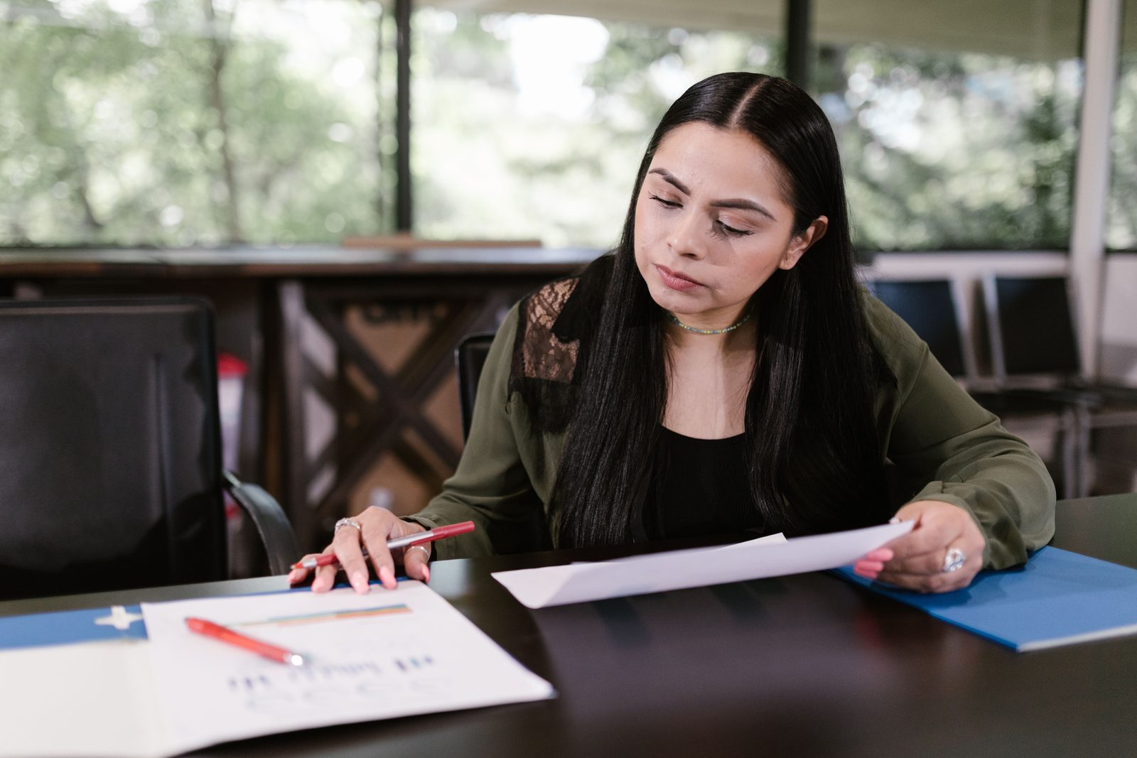 A parent reading insurance paperwork at a table