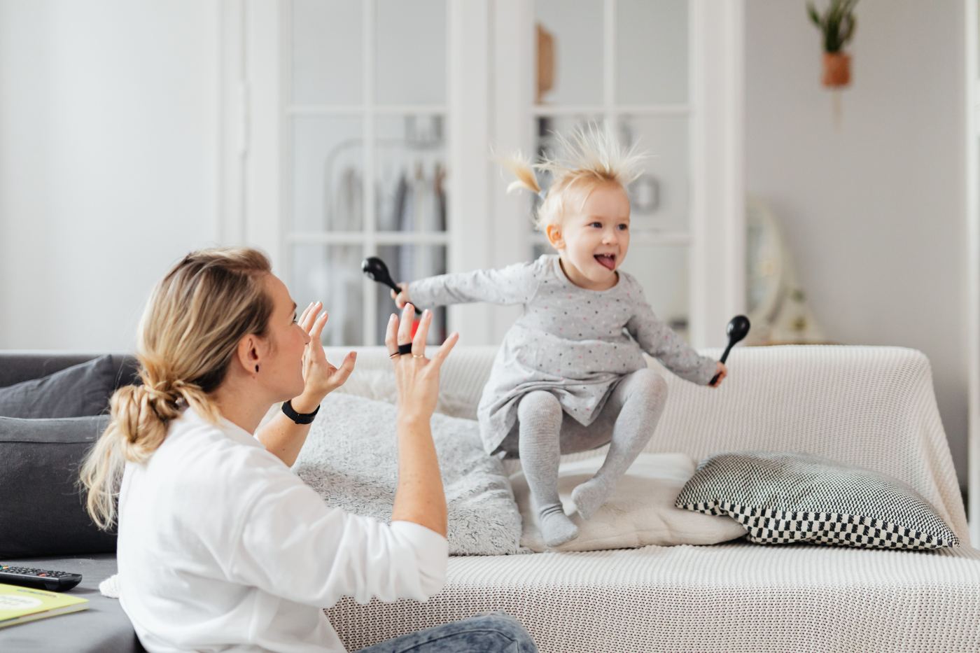 Mother and daughter enjoying a playful moment on the living room sofa