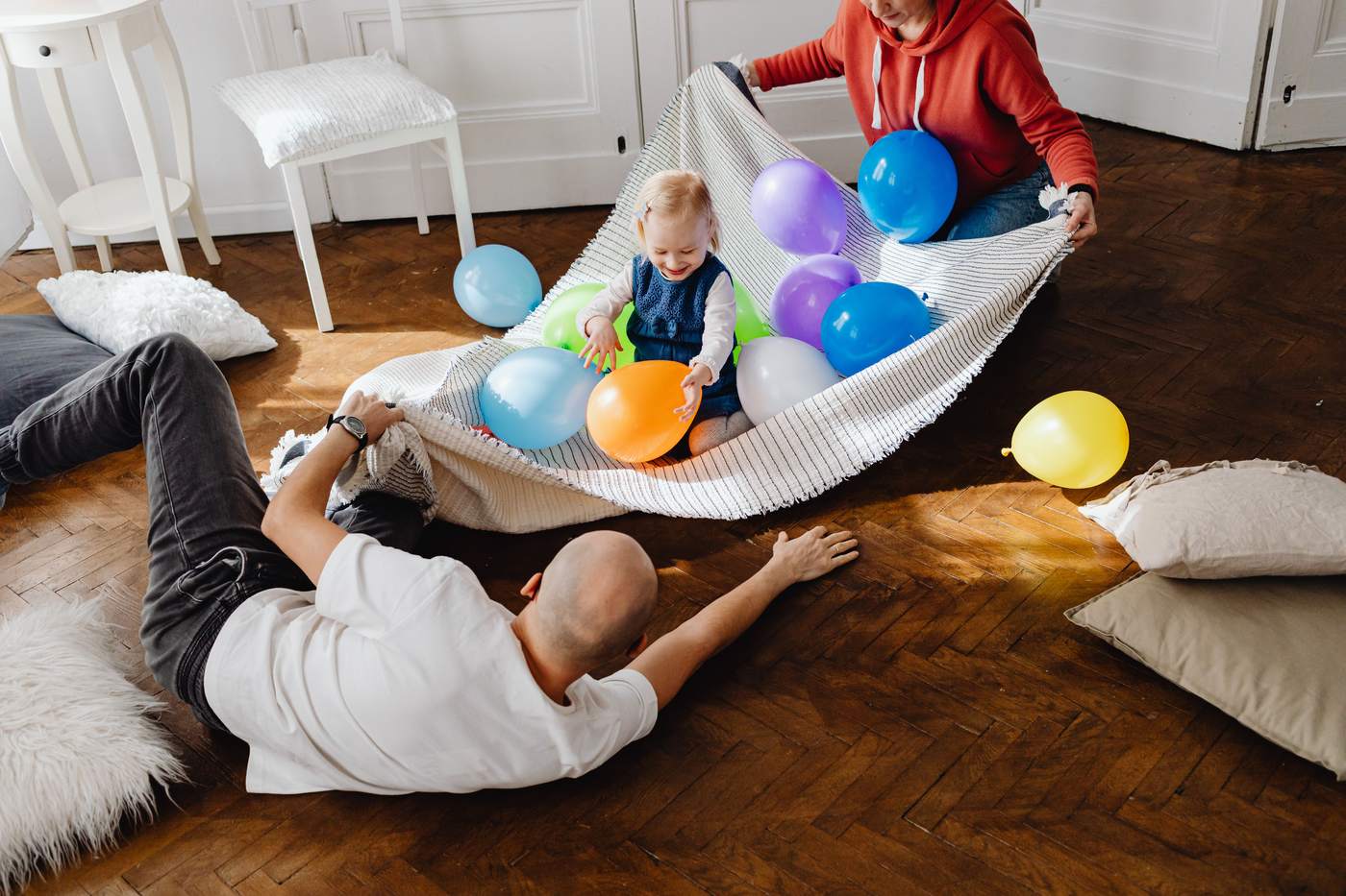 Happy family playing with colorful balloons indoors