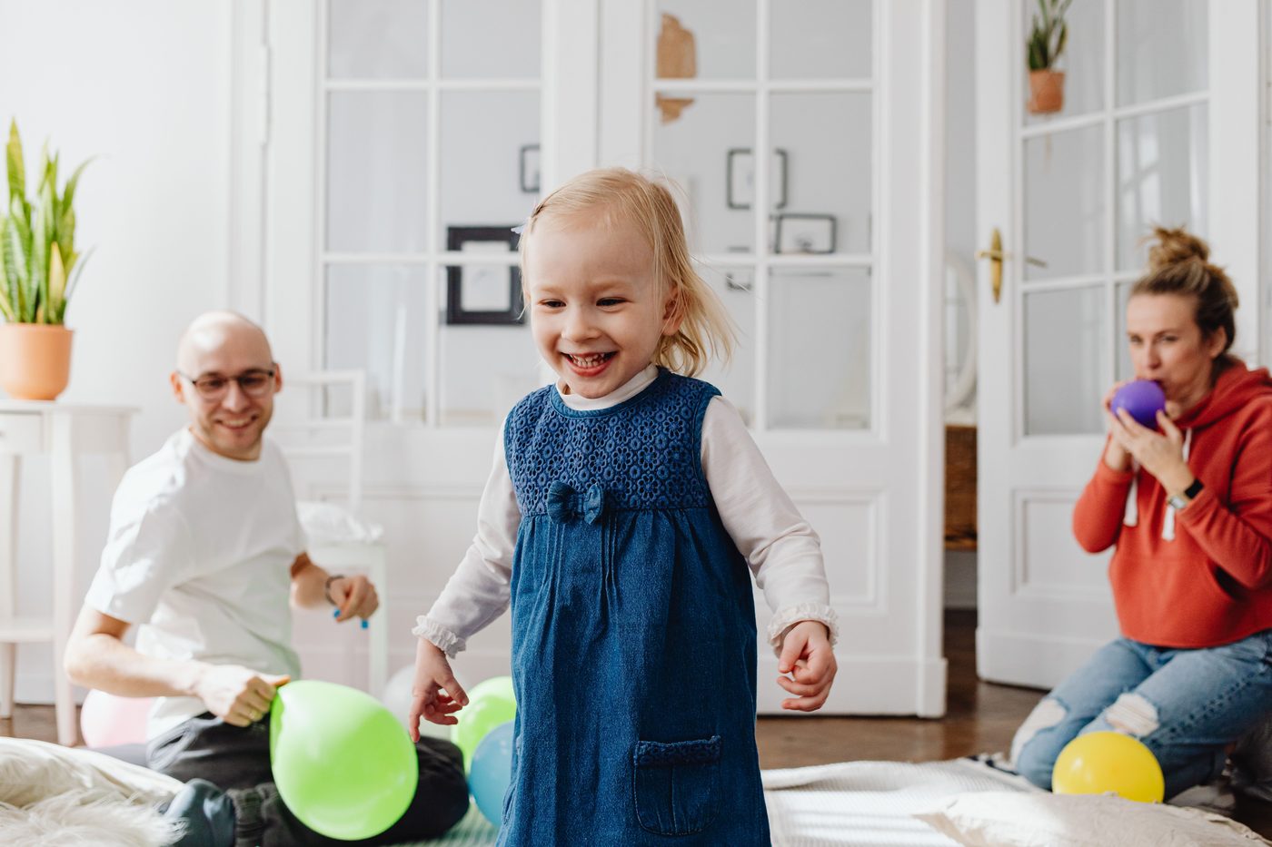 Joyful family playing with balloons indoors