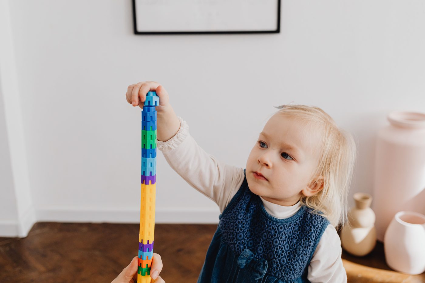 Cute toddler stacking colorful blocks at home