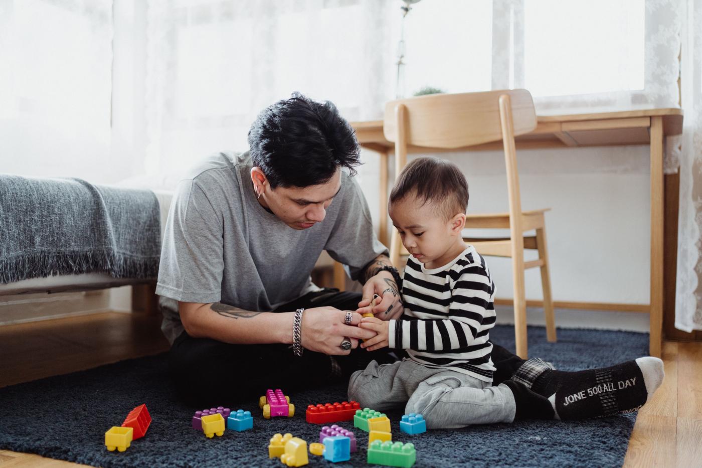 Father and son bond playing with colorful blocks in a cozy home setting