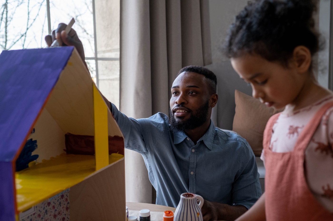 A father and daughter enjoying creative time painting together indoors