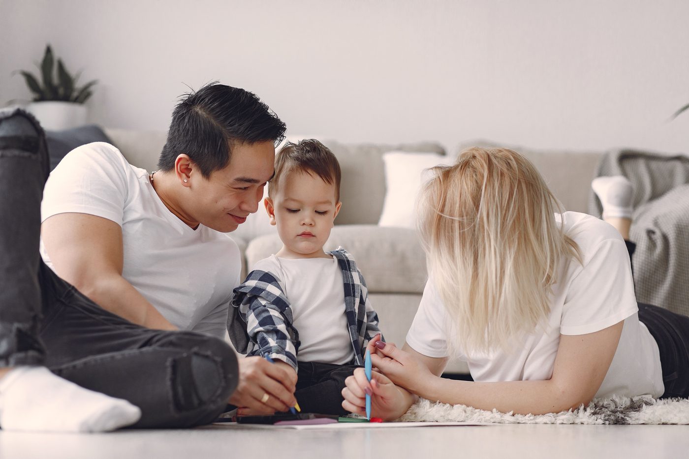 Family enjoying quality time drawing together on the living room floor