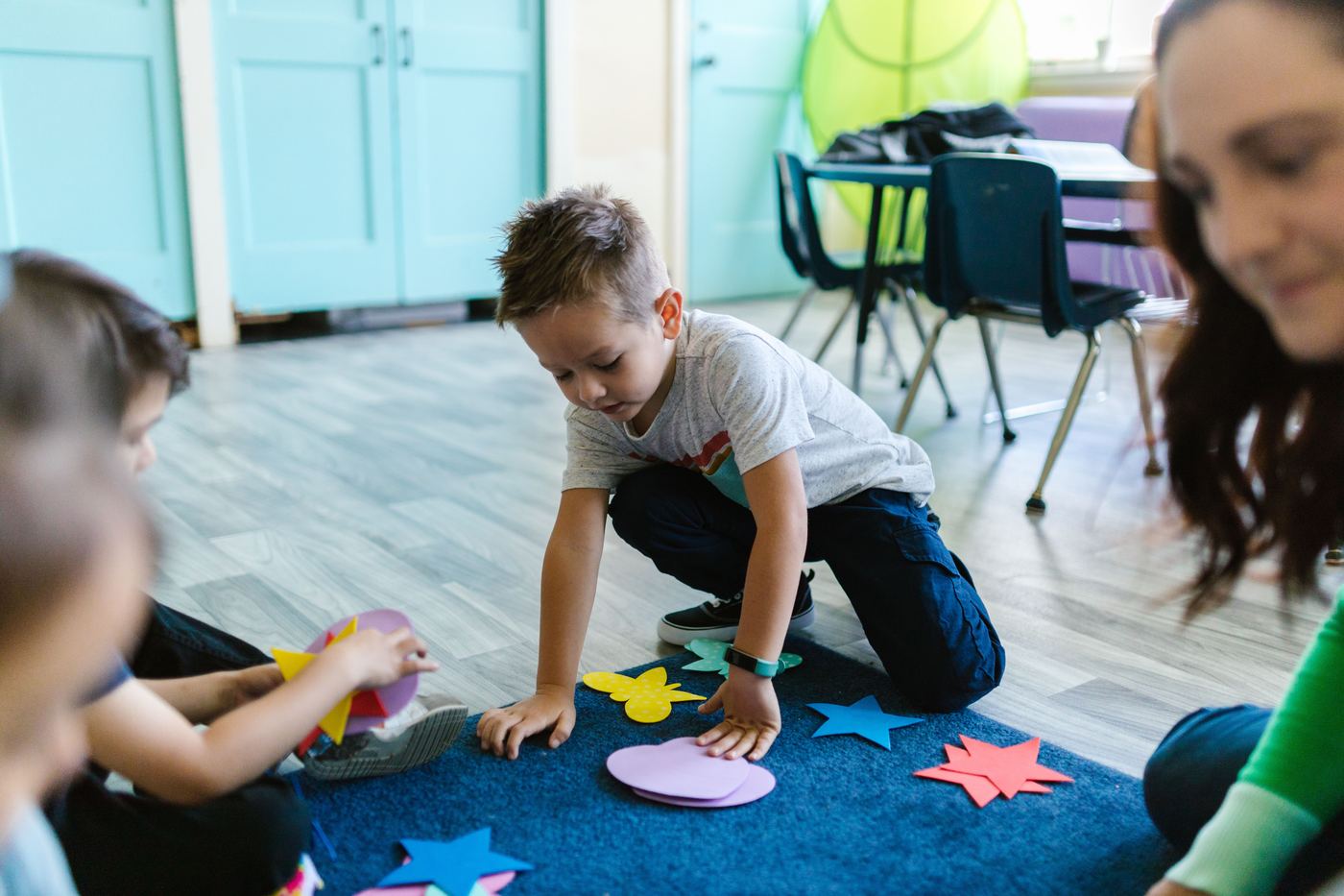 Children playing with colorful shapes in a classroom setting