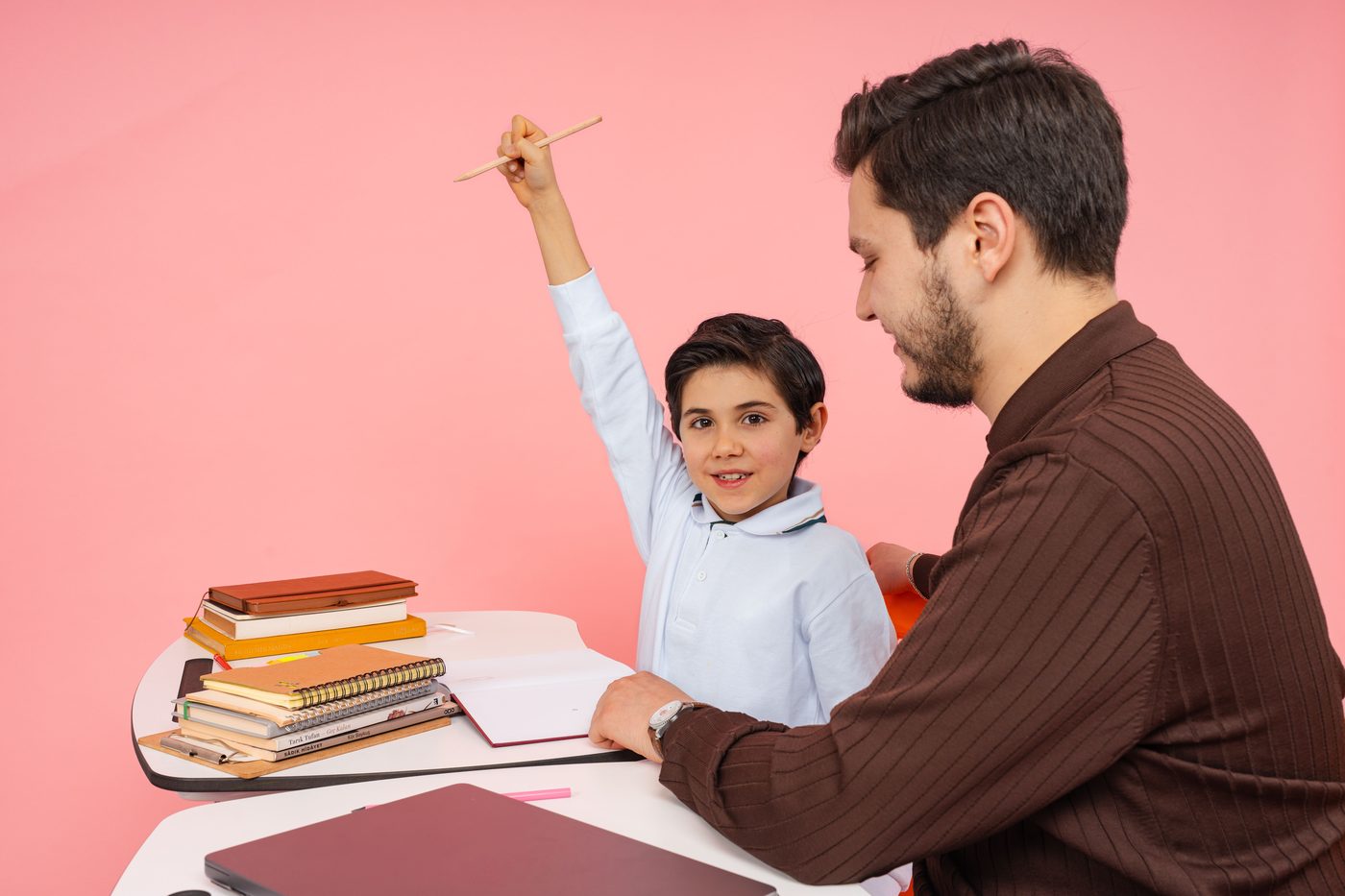 Teacher aids enthusiastic student in classroom setting