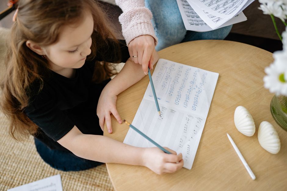 A behavior analyst taking notes while a young child plays at home