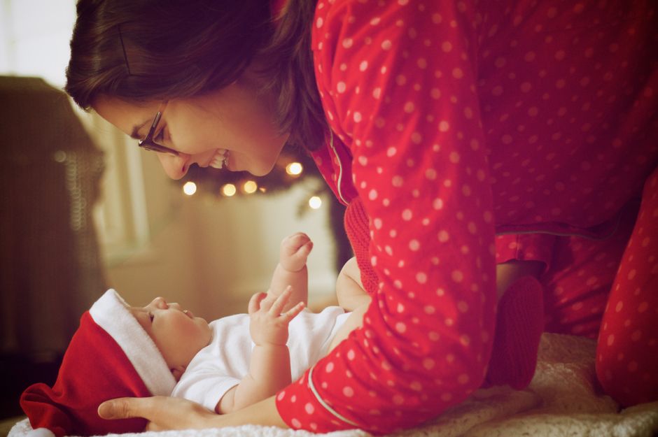 Parent holding and smiling at their baby at home