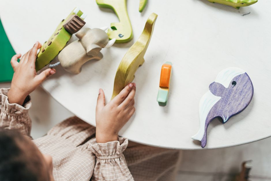 Young girl playing alone with figurines, lost in her own world