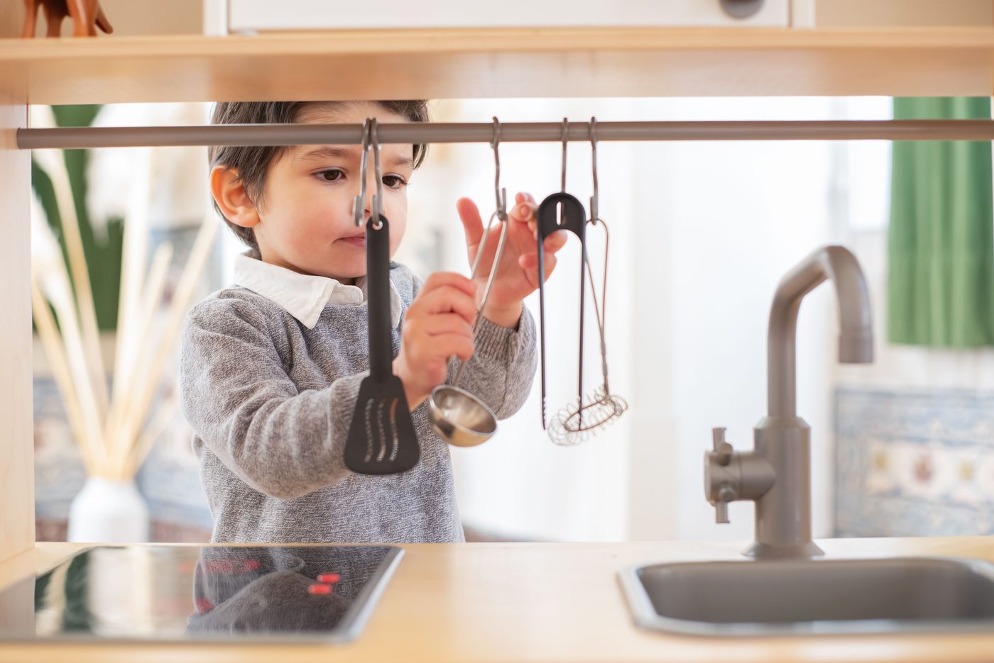 A young child having fun exploring kitchen utensils in a cozy indoor setting