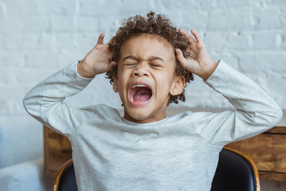 Child covering their ears, overwhelmed by sensory input